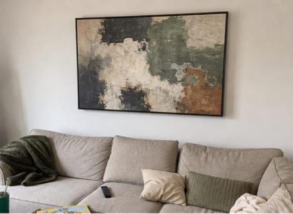 Large framed abstract canvas above a lived-in sofa