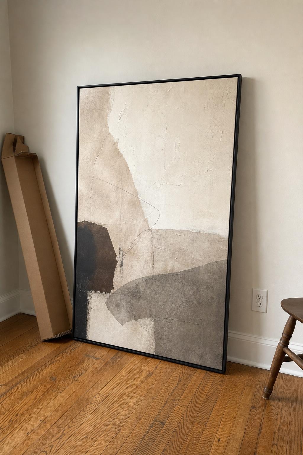 Large canvas artwork leaning on the floor with a cardboard shipping box nearby